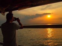 Dave Dean taking a photo of the sunset abroad with his smartphone